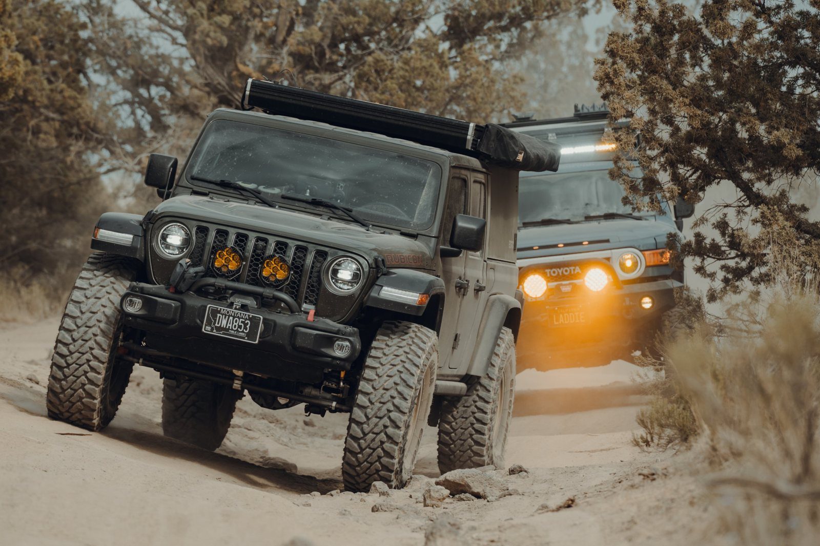 Jeep Gladiator Rubicon climbing a sandy trail, FJ Cruiser behind it