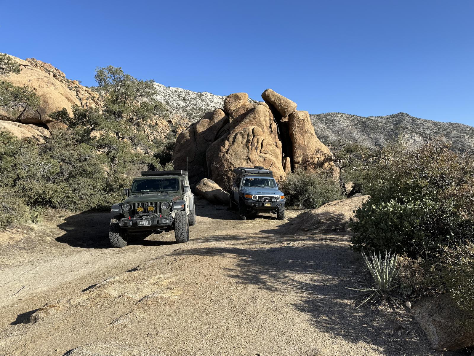 The Gladiator and the FJ parked among granite boulders