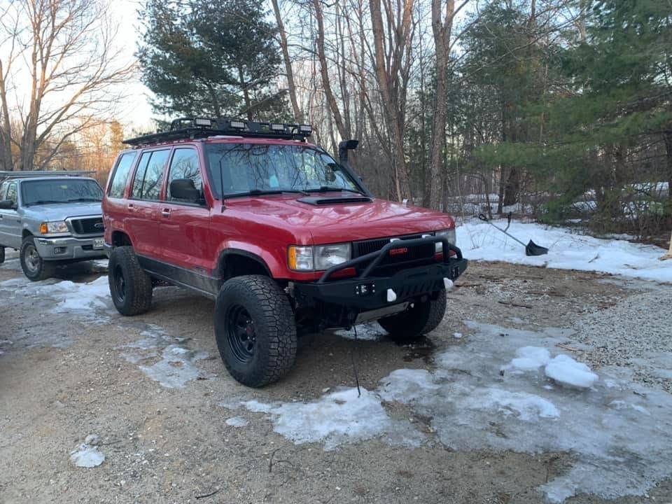 Red Isuzu Trooper with the EAG bumper, roof rack and snorkel, three-quarter view in the snow