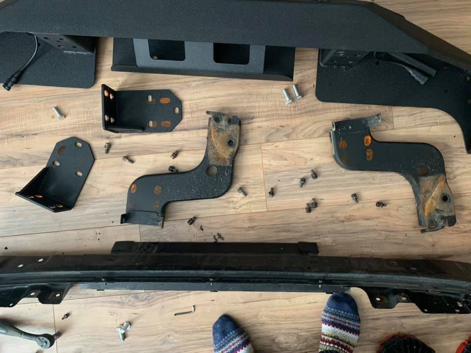 The OEM Trooper bumper bar, its two mounting brackets and the EAG Jeep brackets laid out on the floor