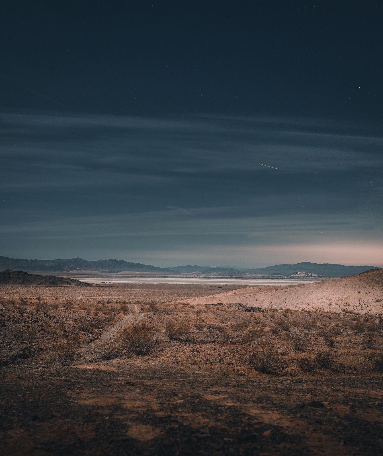 The dry lake at night, two-track leading in