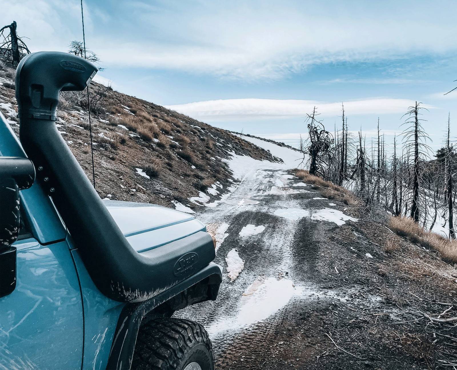 FJ on a snowy burn-scar road